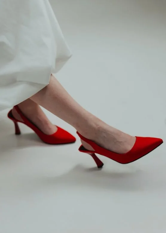 Classic white dress paired with vibrant red heels for a confident and eye-catching look.