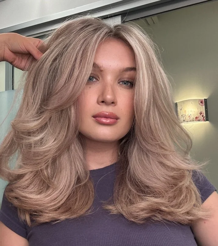Rose gold blonde hair with a soft pink finish against pale skin.