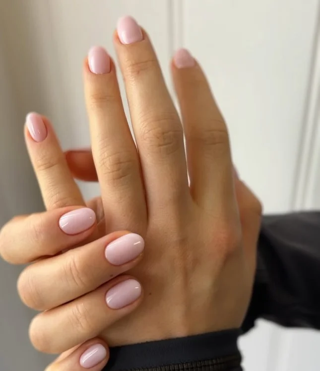 Sheer nude manicure balancing a detailed green dress outfit.