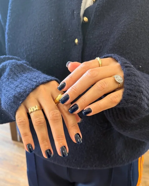 Shimmering navy nails matching an elegant navy blue dress.