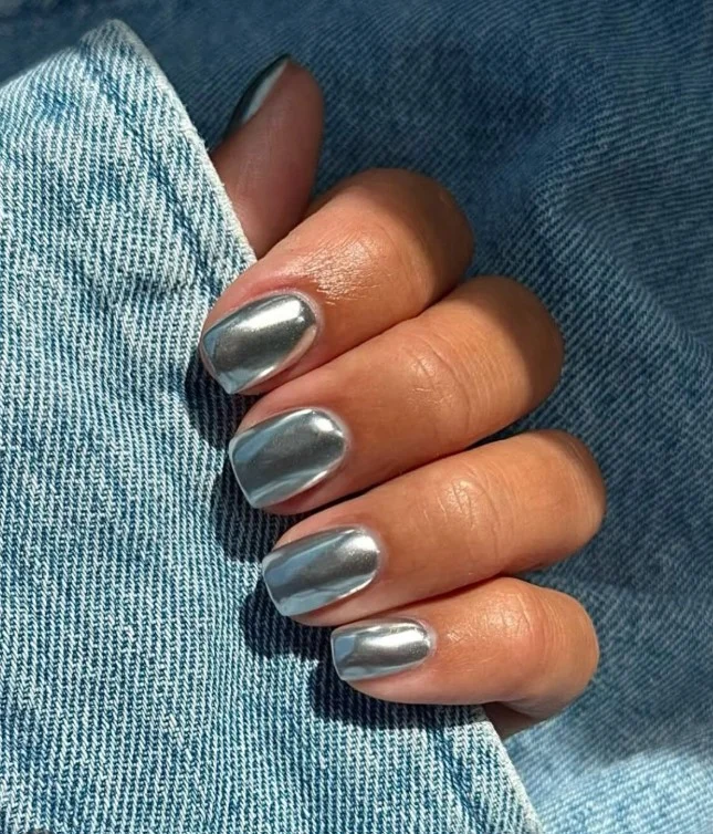 Silver metallic nails paired with a formal green dress for evening events.