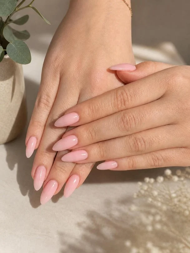 Soft blush pink almond nail designs with a glossy finish for a timeless feminine manicure.