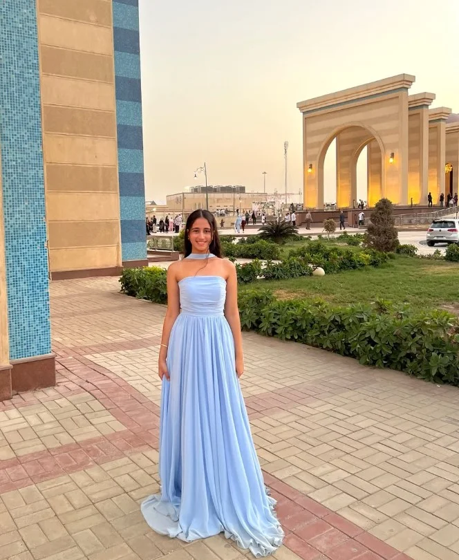 Strapless sky blue prom dress with a full skirt and Hollywood waves