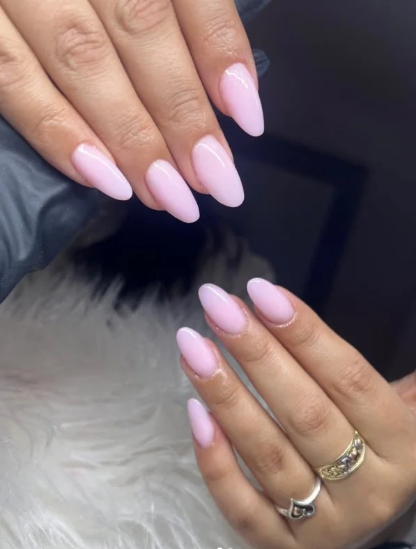 Long nails painted in creamy strawberry milkshake pink with a smooth glossy salon finish.