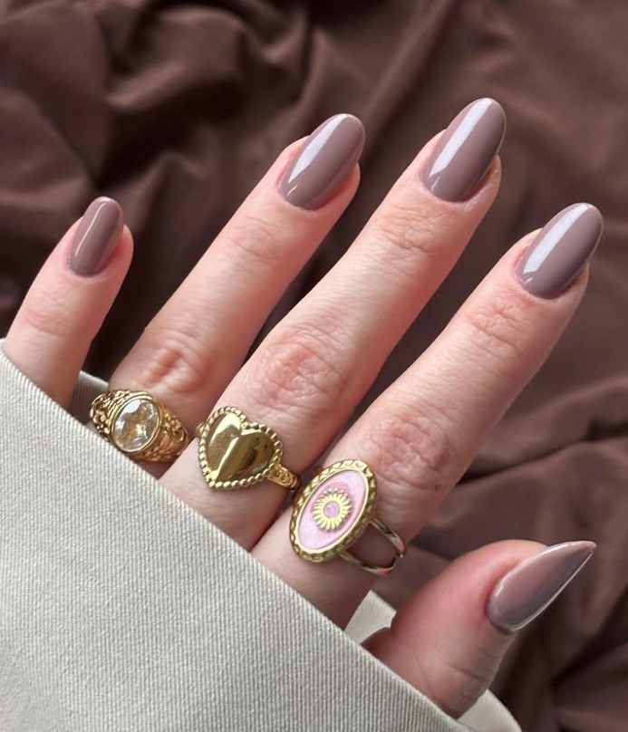 Soft taupe manicure creating a polished look with a navy blue outfit.