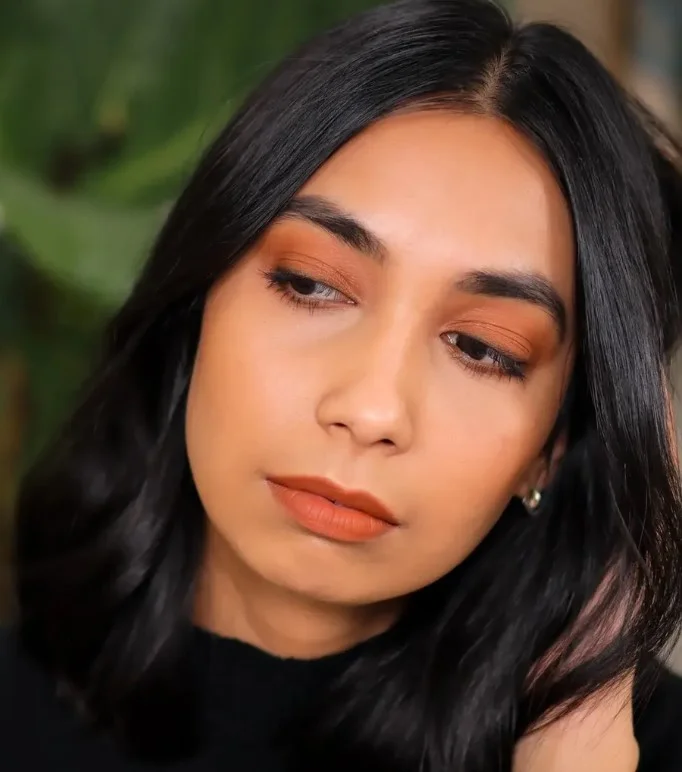 Terracotta lipstick that enhances golden olive undertones with a warm earthy glow.