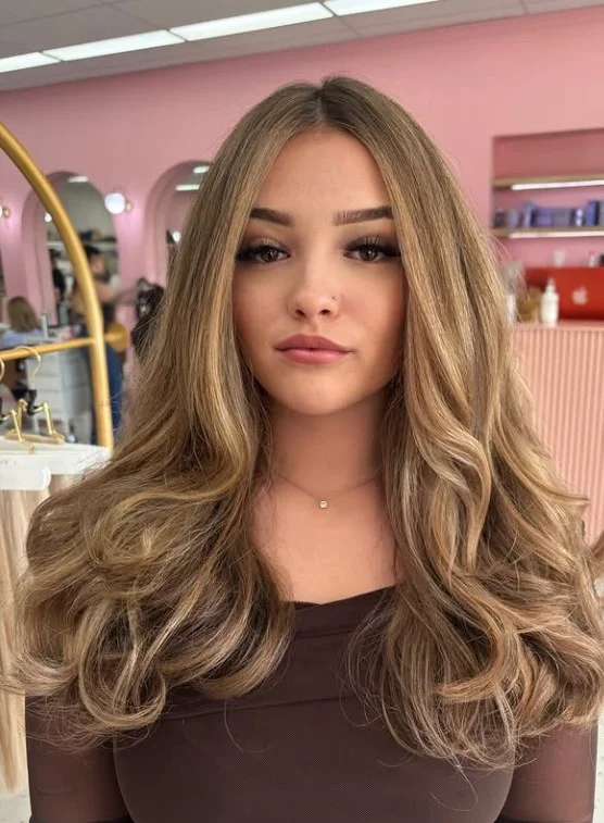 Warm honey blonde hair creating a soft golden glow against pale skin.