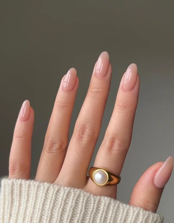 Warm nude nails styled with an emerald green evening dress.