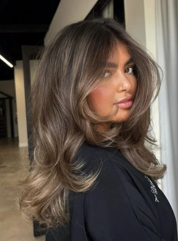 Ash brown hair color styled on red-toned skin for a soft, balanced brunette look.