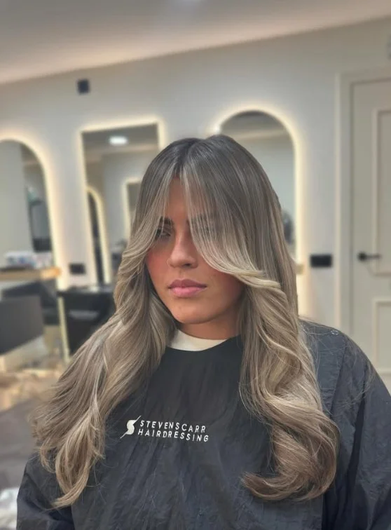 Ashy bronde highlights adding soft blonde and brown dimension to the hair.