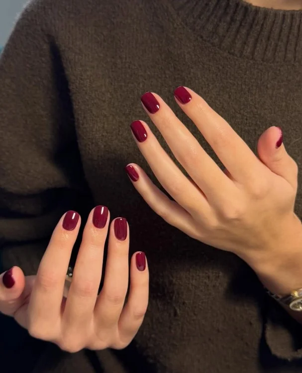 Rich berry nail varnish complementing pale skin with a sophisticated winter manicure look.