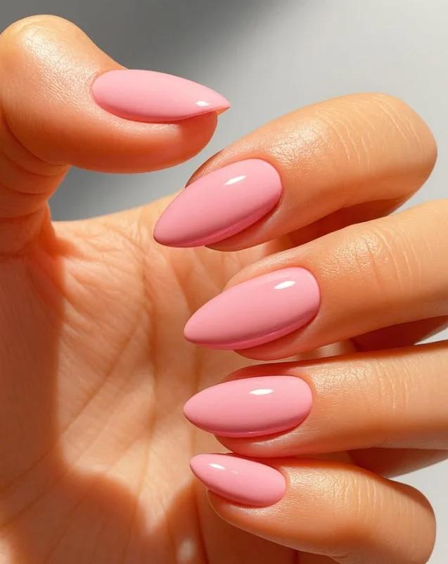 Soft blush pink nail varnish on pale skin creating a delicate feminine manicure.