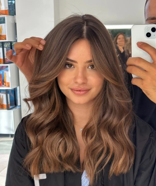 Caramel brown hair with subtle dimension complementing warm red-toned skin.
