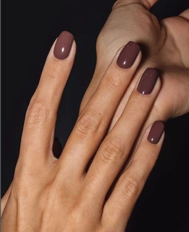 Caramel brown nail polish complementing tan skin with a rich glossy finish.