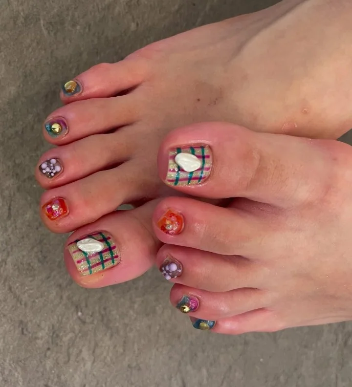 Christmas plaid toe nails featuring red, green, and white plaid holiday patterns