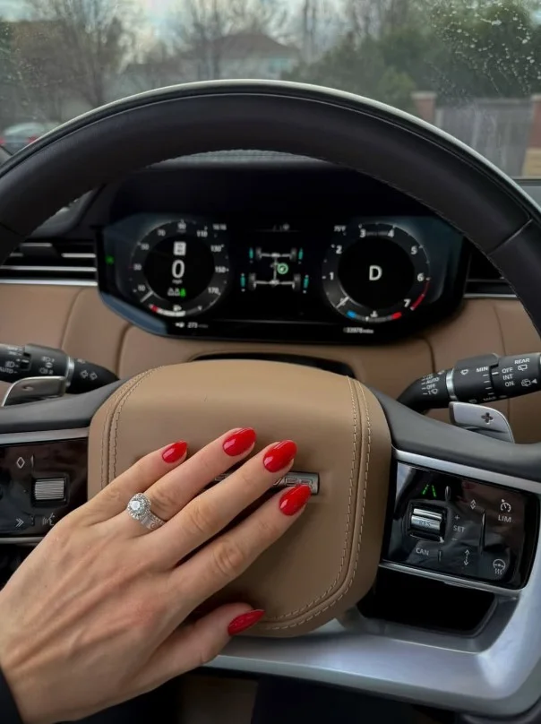 Classic blue-based red nail varnish creating elegant contrast against pale skin.