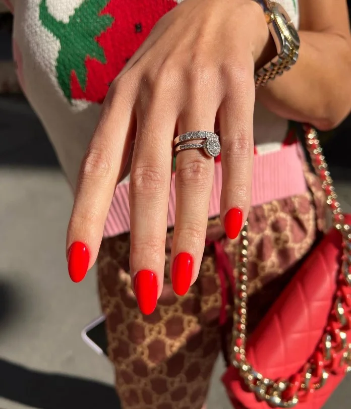 Classic red manicure creating an elegant contrast against tan skin.