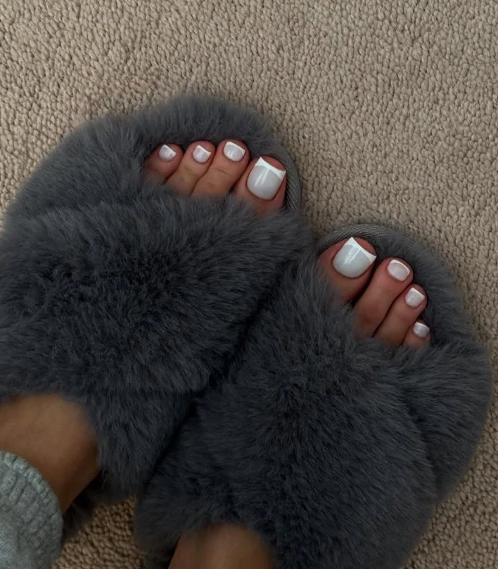 Classic white French toe nail design with nude base