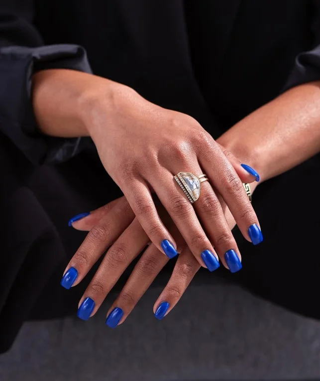 Cobalt blue nail polish creating a bold modern contrast against tan skin.