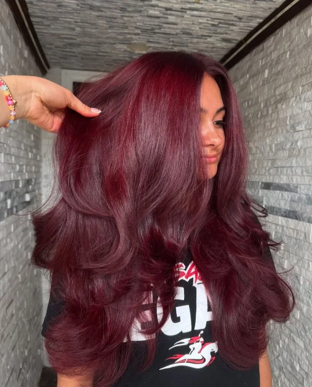 Deep burgundy hair color creating an elegant contrast with red-toned skin.