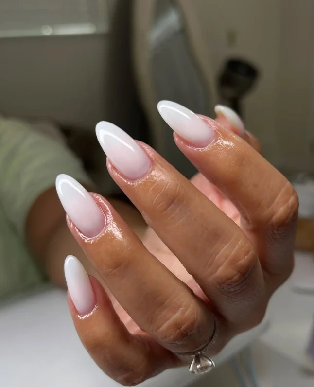 Milky white nails creating a fresh contrast against a tan complexion.