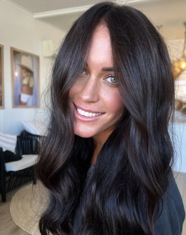 Neutral dark brown hair creating a polished frame around a red-toned complexion.