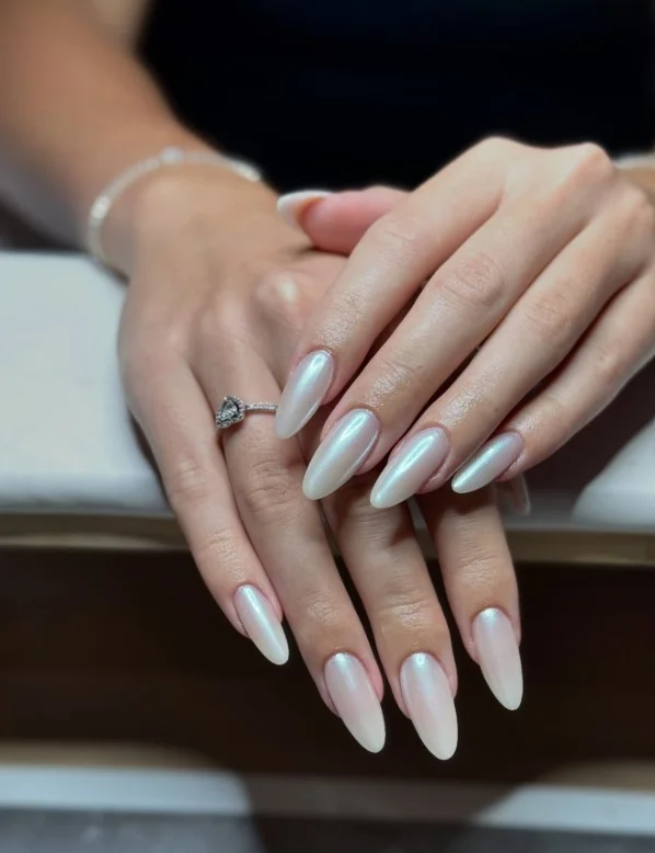 Pearl white nail varnish on pale skin with a luminous glossy finish for an elegant manicure.