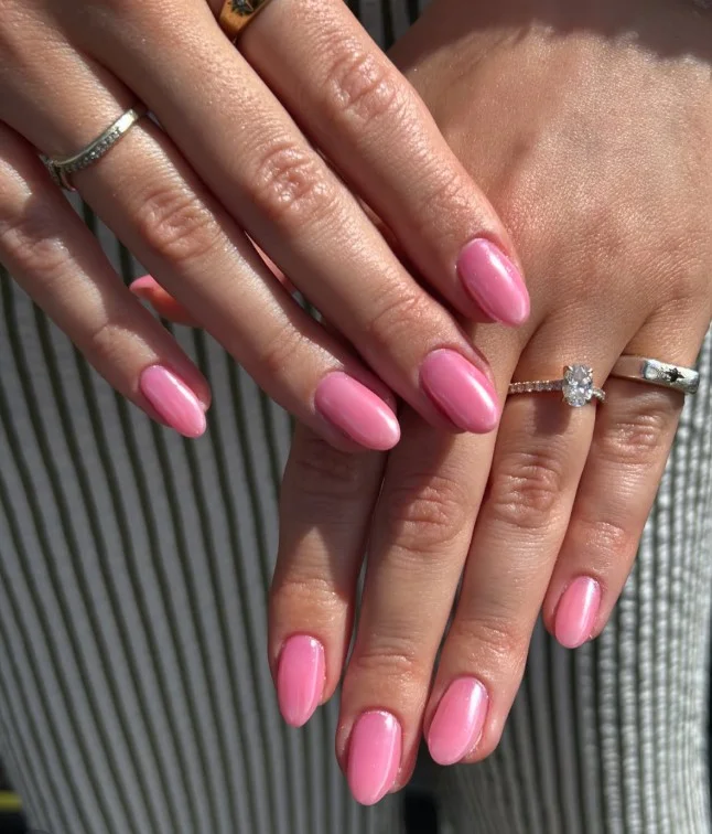 Rose pink nails giving tan skin a soft feminine and polished appearance.