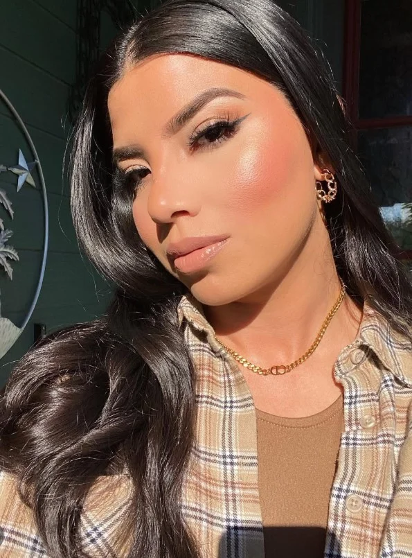 Warm coral blush on olive skin creating a radiant sun-kissed makeup look