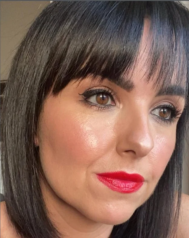 Warm tomato red lipstick complementing golden undertones on fair skin.