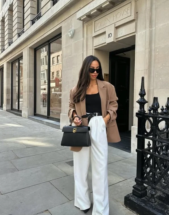 Woman wearing white jeans with an oversized blazer and simple fitted top for a polished everyday outfit.
