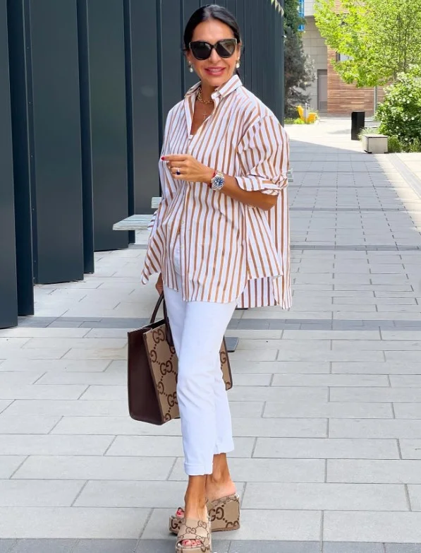 Woman wearing white jeans with a classic striped shirt and casual shoes for an effortless weekend outfit.