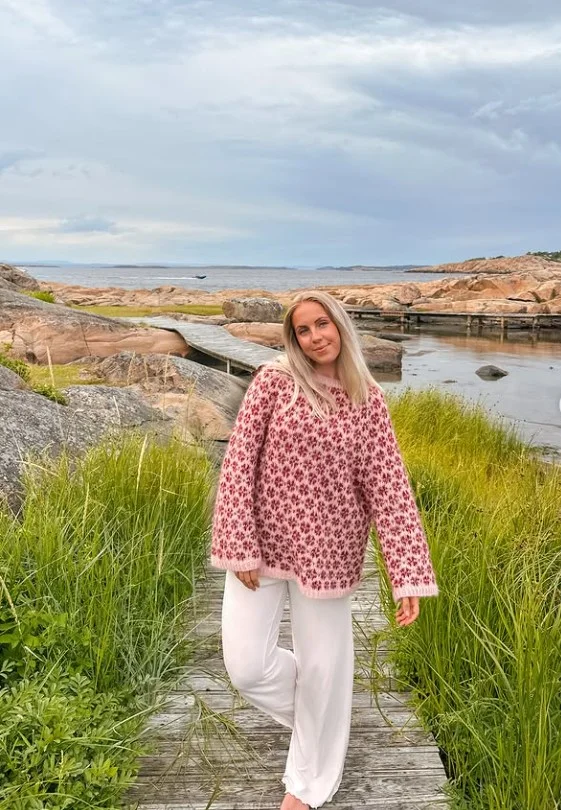 Woman wearing white jeans with a black-and-white patterned sweater and loafers for a stylish casual outfit.