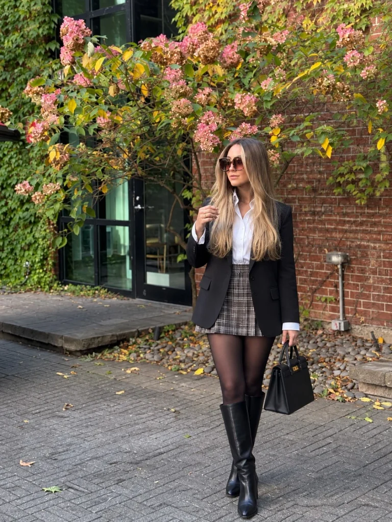 Black blazer with white button-down, plaid mini skirt, tights, and knee-high boots