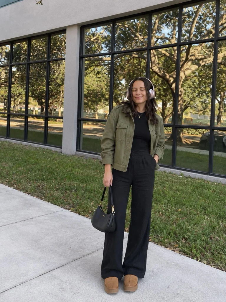 Woman wearing black linen pants with an olive utility jacket, black top