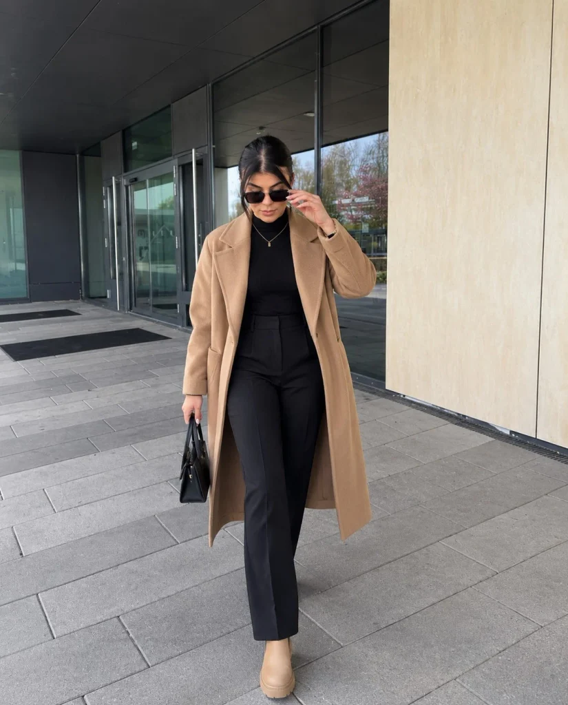 Woman wearing beige Chelsea boots with black tailored trousers and a knit sweater