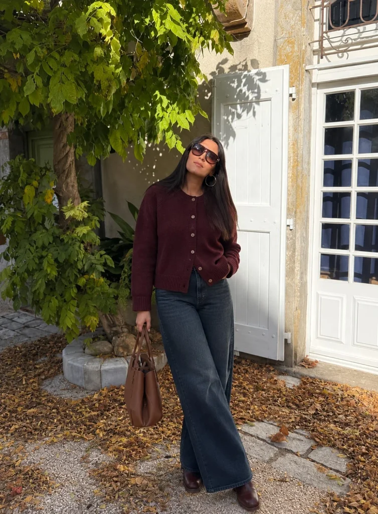 Woman wearing dark wide-leg jeans with a burgundy cardigan and ankle boots
