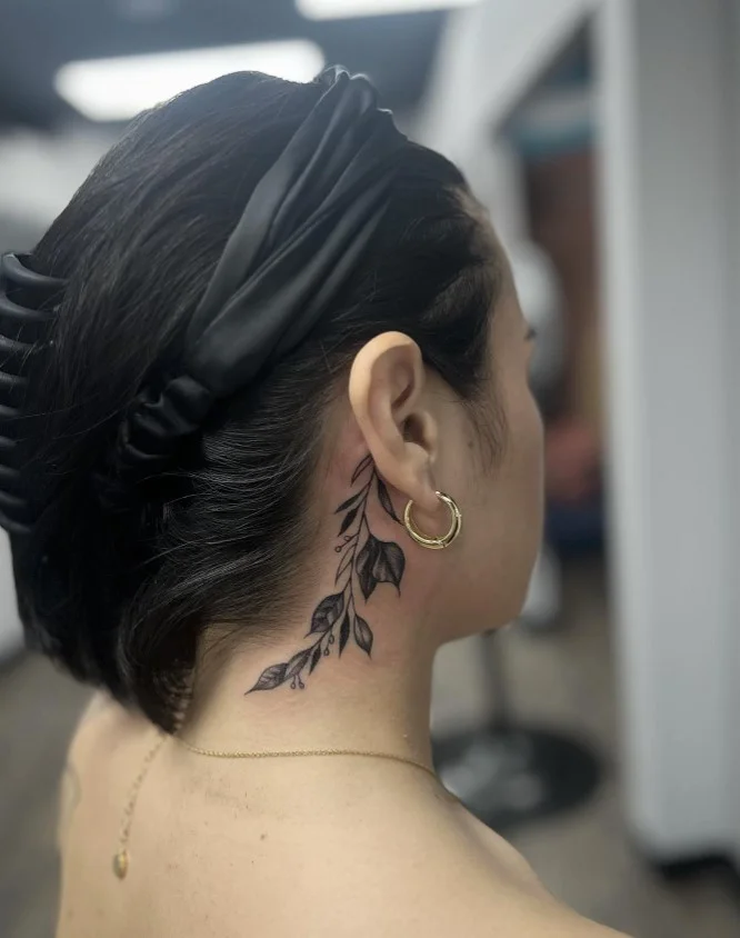 Floral vine behind the ear tattoo with a delicate botanical design