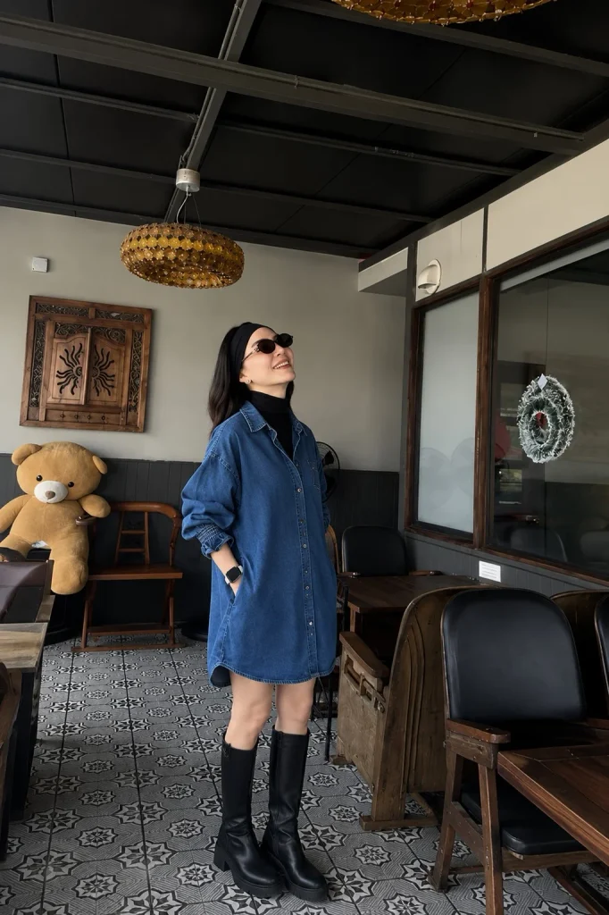 Long black boots with a shirt dress layered over a turtleneck