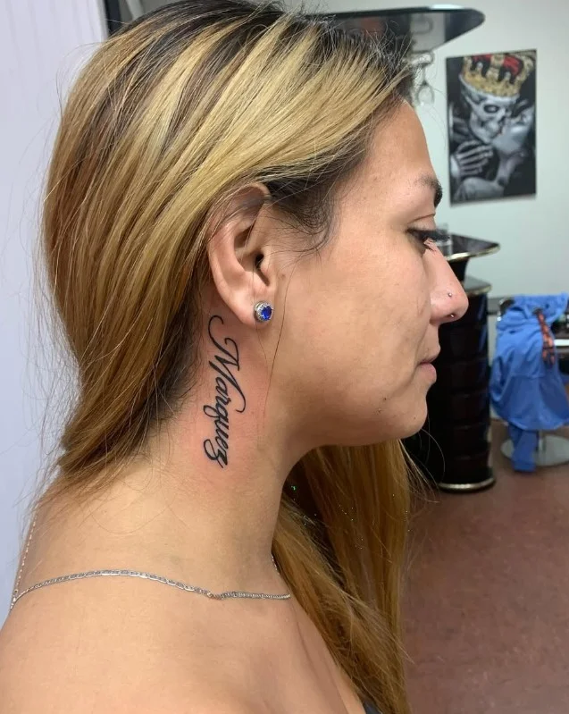 Name or date behind the ear tattoo with delicate personalized lettering