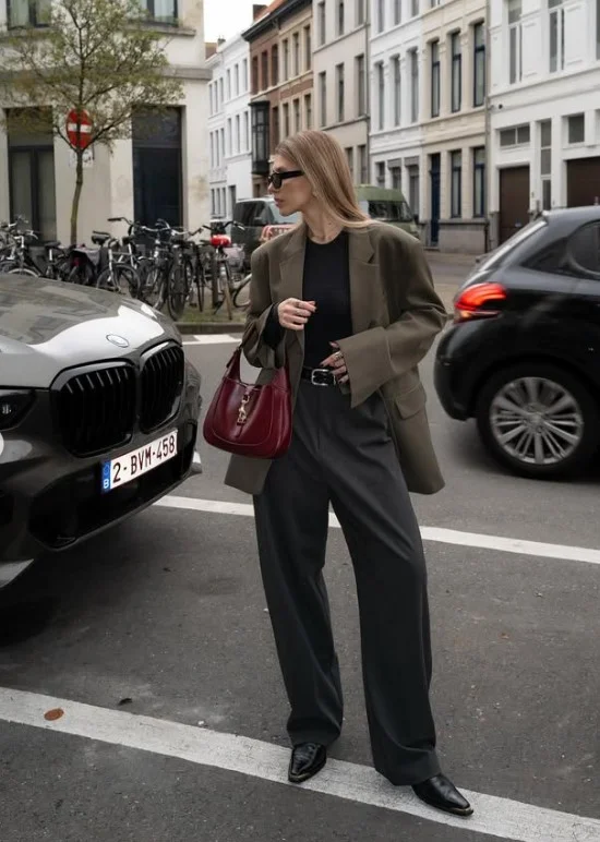 Woman wearing pointed-toe boots with black tailored trousers and a blazer