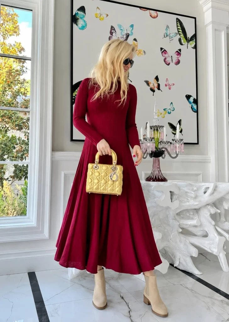 Woman wearing beige Chelsea boots with a sweater dress and long coat