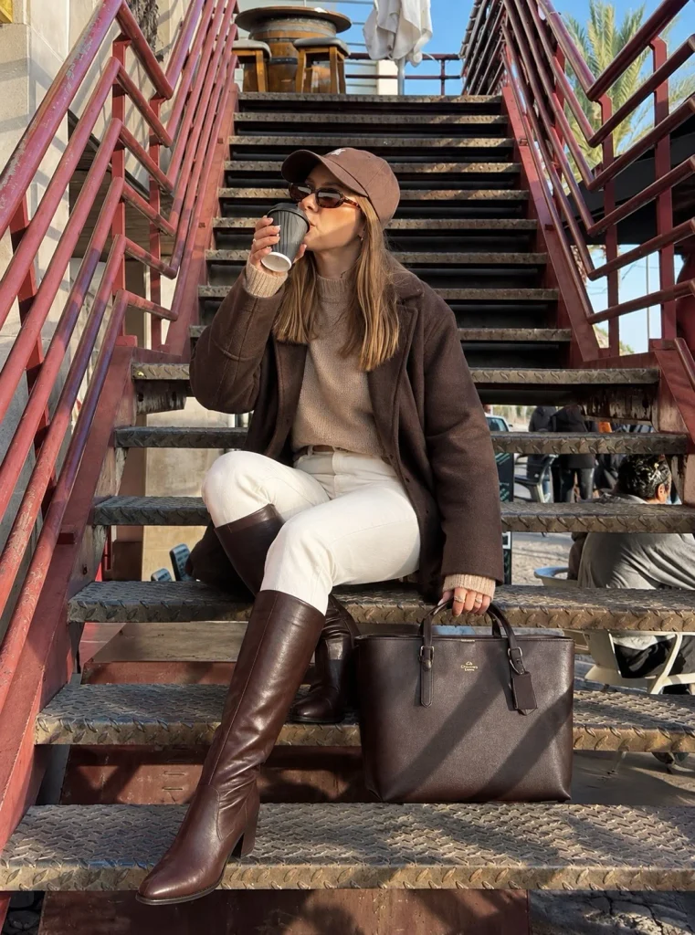 White jeans and neutral sweater with dark brown knee high boots