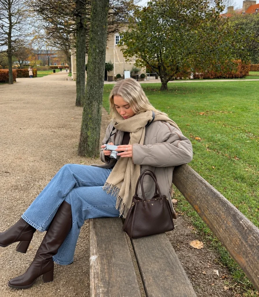 Wide-leg jeans and fitted top styled with dark brown knee high boots