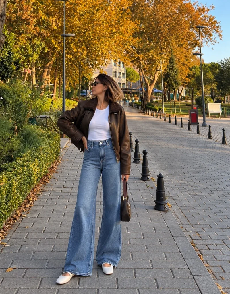 Woman wearing wide-leg jeans with a leather jacket, white T-shirt, and Mary Jane shoes