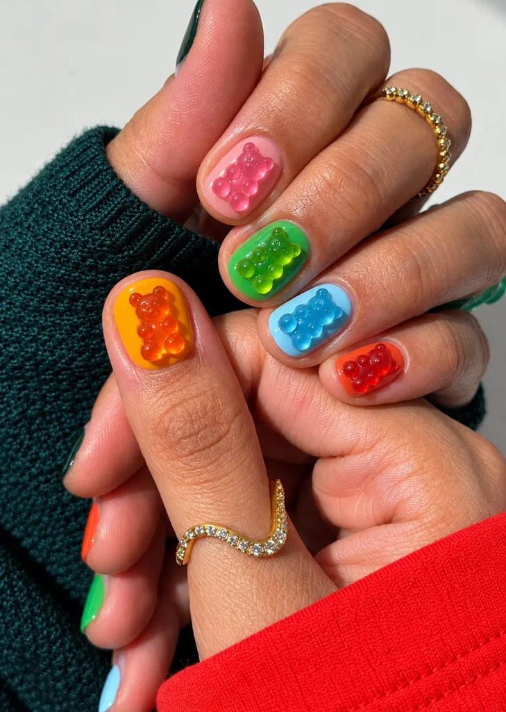 Colorful acrylic nails decorated with raised, translucent gummy bear nail charms.