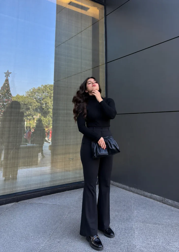 Minimalist winter outfit with a black turtleneck, tailored trousers, and black leather loafers