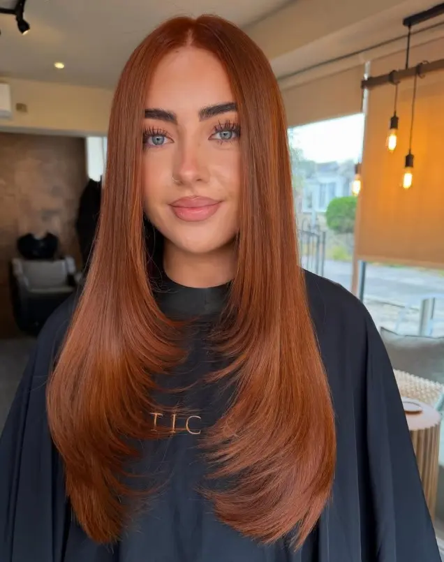 Bright copper hair in a vivid red-orange shade that contrasts with blue eyes and pale skin