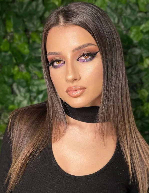 Woman wearing warm caramel nude lipstick with a polished natural makeup look on brown skin