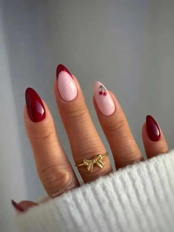Cute acrylic nails featuring red cherry nail art with green stems on a nude base.